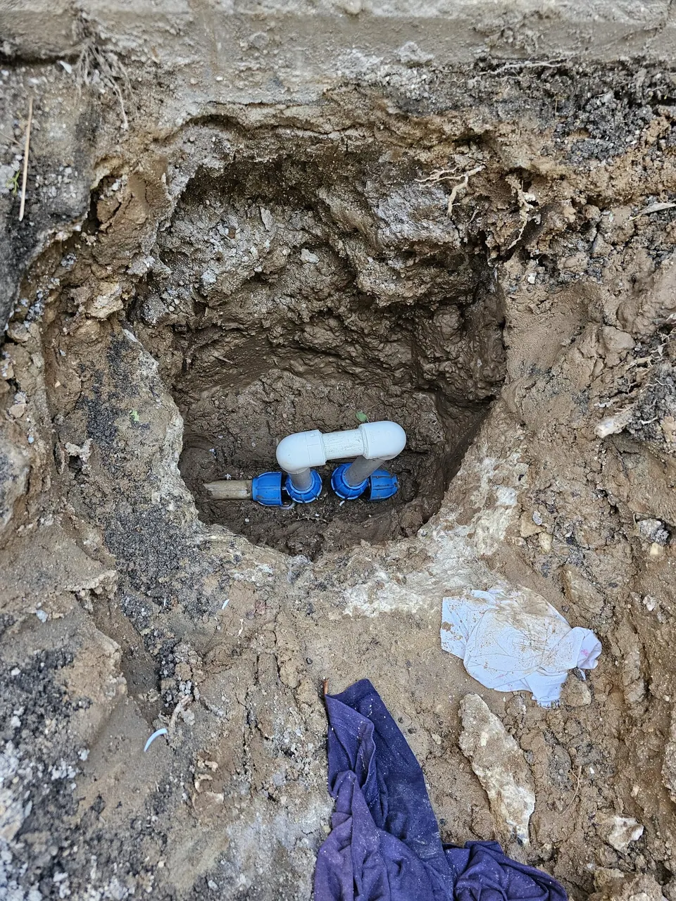 Toprak altında açılmış alandaki boru bağlantısı ve mavi ek parçalar
